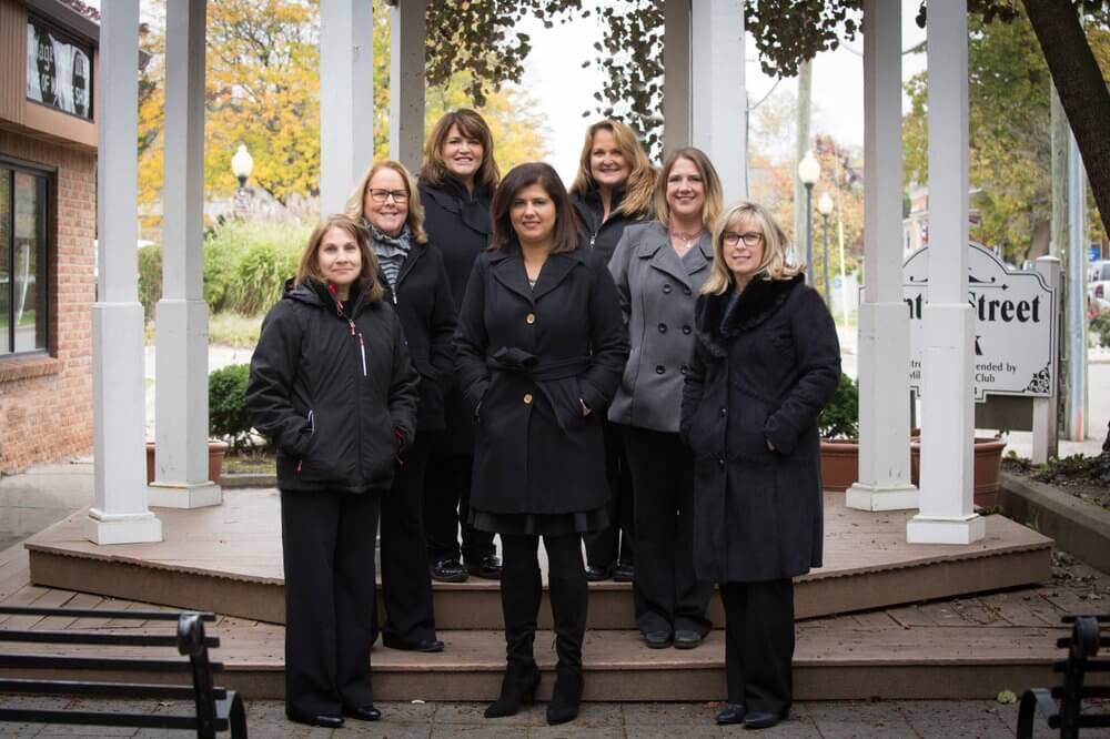 Group of women standing on a wooden platform outdoors.