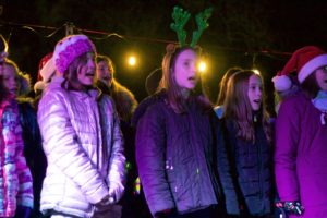 Children singing at outdoor holiday event.