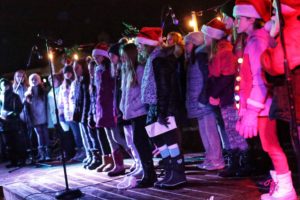 Children's choir singing in festive holiday attire.