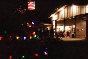 Fire station with holiday lights and American flag.