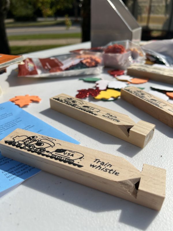 Wooden train whistles and craft supplies on a table.