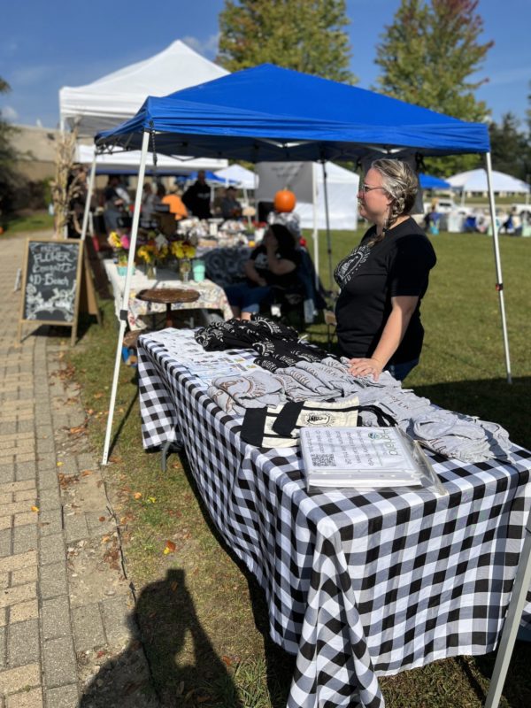 Outdoor market with vendor and merchandise display.