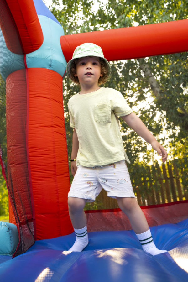 Child playing on inflatable bounce house outdoors.